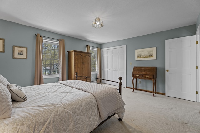 carpeted bedroom featuring baseboards and a closet