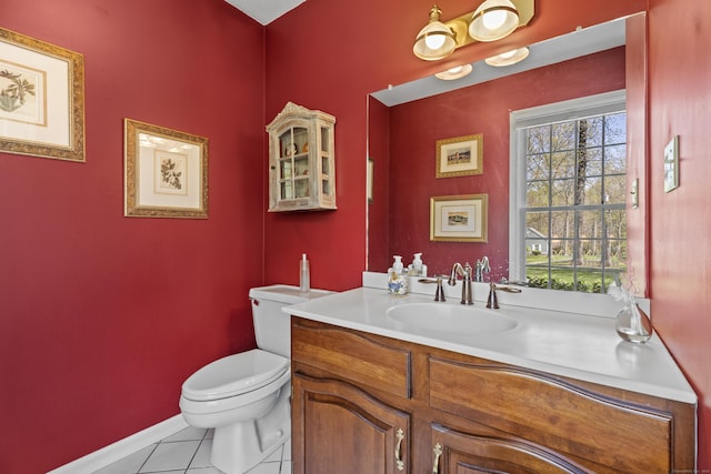 half bath featuring baseboards, tile patterned flooring, vanity, and toilet