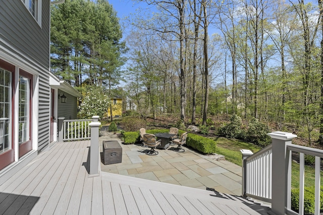 wooden terrace featuring a patio and an outdoor fire pit