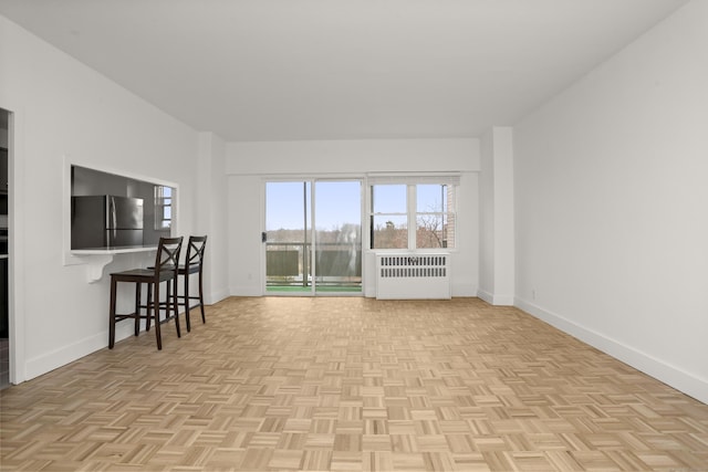 living area featuring radiator heating unit and baseboards