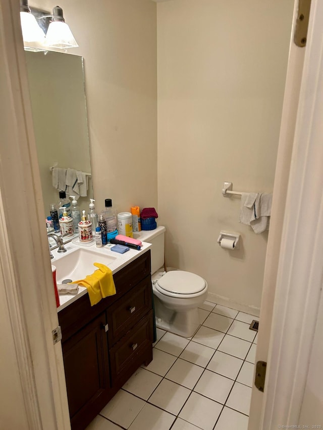 bathroom featuring toilet, tile patterned flooring, and vanity