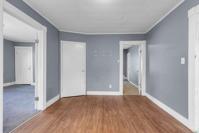 unfurnished room with baseboards, ornamental molding, and wood finished floors
