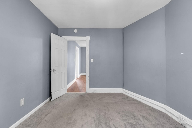 carpeted empty room with baseboards