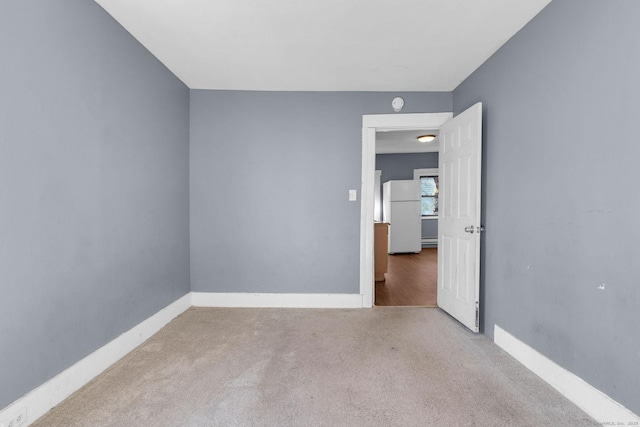 spare room with baseboards and carpet