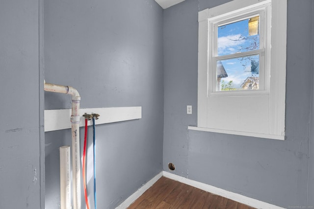 clothes washing area with laundry area, baseboards, and dark wood-type flooring