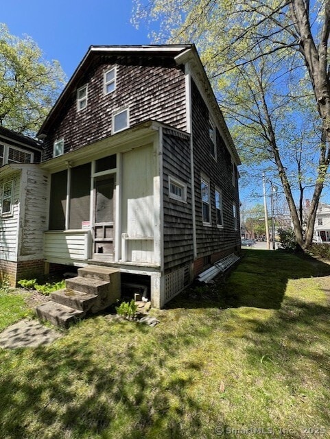 exterior space with a yard, a sunroom, and entry steps