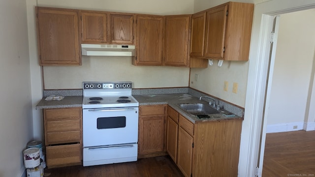 kitchen featuring brown cabinetry, a sink, under cabinet range hood, and white range with electric stovetop