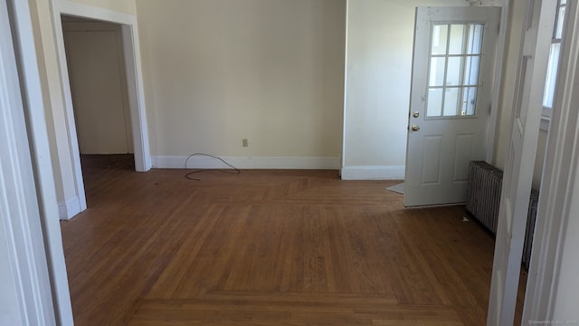 unfurnished room with baseboards and radiator