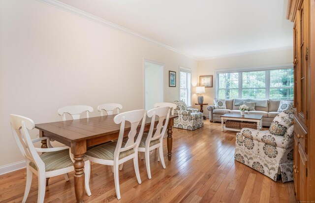 dining room with light wood-style flooring and ornamental molding