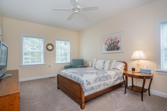 carpeted bedroom with multiple windows, baseboards, and ceiling fan
