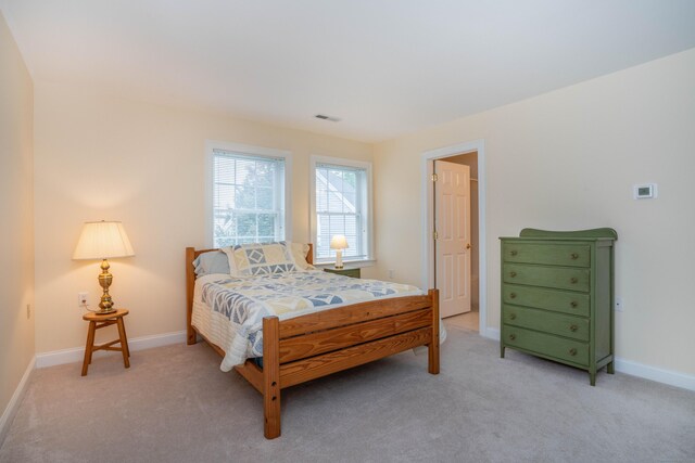 bedroom with light colored carpet and baseboards