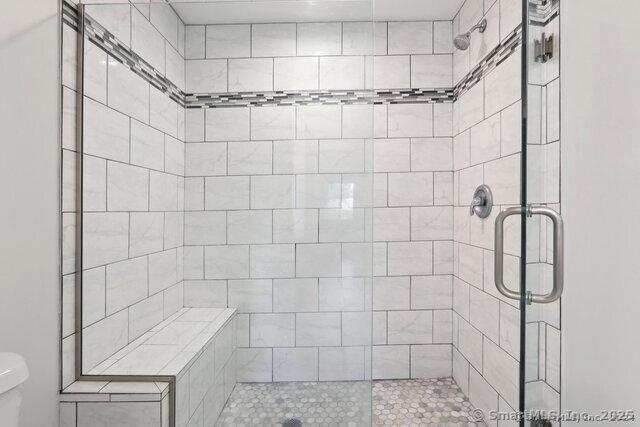 bathroom with toilet and a stall shower