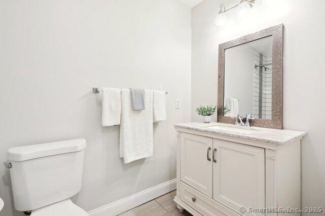 bathroom with baseboards, vanity, and toilet