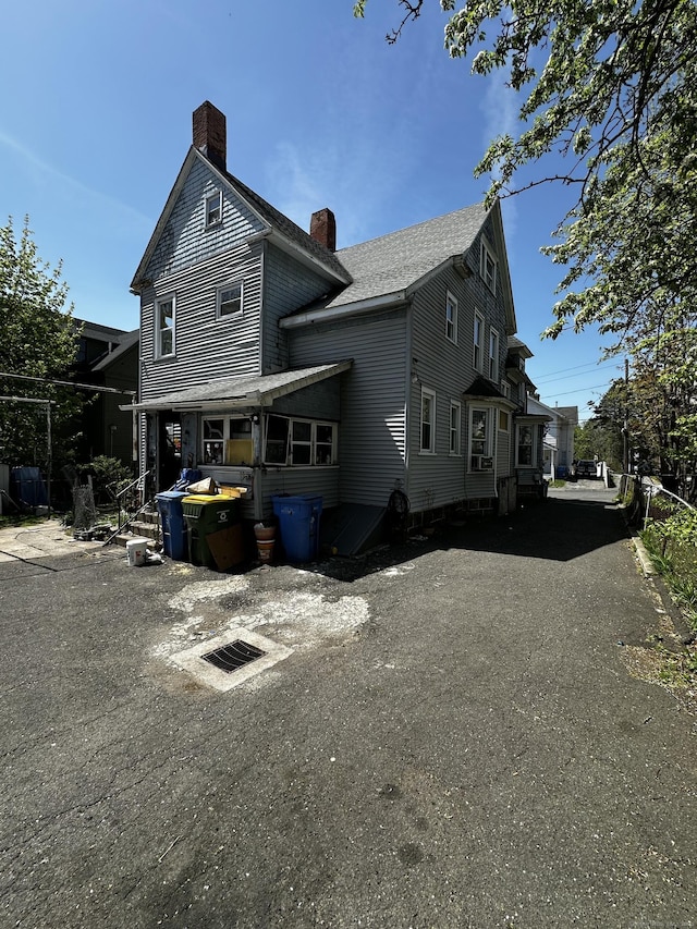 view of home's exterior featuring roof with shingles and a chimney