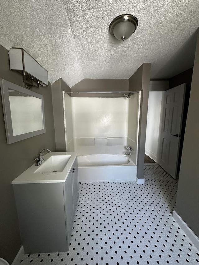 bathroom with baseboards, a textured ceiling, and tub / shower combination