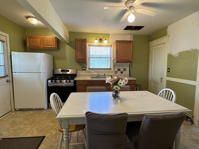 33 E Brown St, West Haven, CT 06516 - kitchen with stainless steel gas range oven, freestanding refrigerator, brown cabinetry, and visible vents