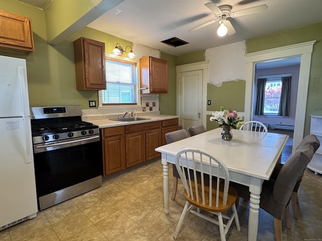 33 E Brown St, West Haven, CT 06516 - kitchen with a sink, freestanding refrigerator, stainless steel range with gas cooktop, and brown cabinetry