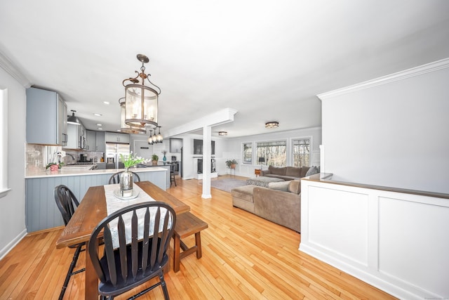 dining area featuring crown molding, recessed lighting, light wood finished floors, and a chandelier