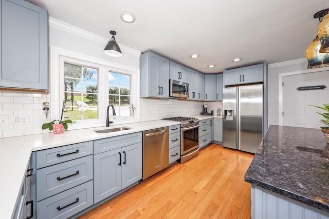 kitchen featuring a sink, crown molding, backsplash, and stainless steel appliances