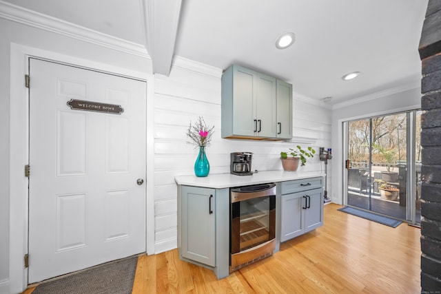 bar featuring crown molding, recessed lighting, light wood finished floors, and wine cooler