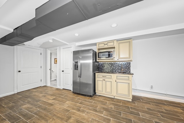 kitchen featuring dark wood-type flooring, stainless steel appliances, recessed lighting, and cream cabinetry