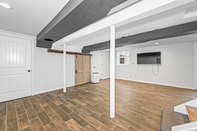 basement featuring baseboards, recessed lighting, and wood finished floors
