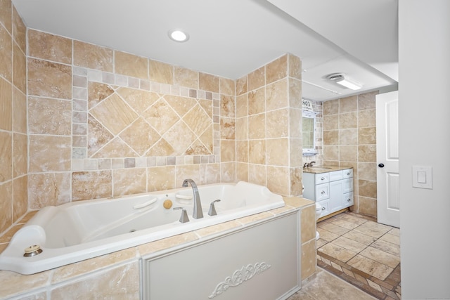 full bathroom with a jetted tub, tile walls, vanity, and recessed lighting