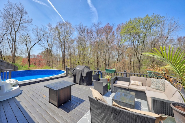 wooden terrace featuring outdoor lounge area and an outdoor pool
