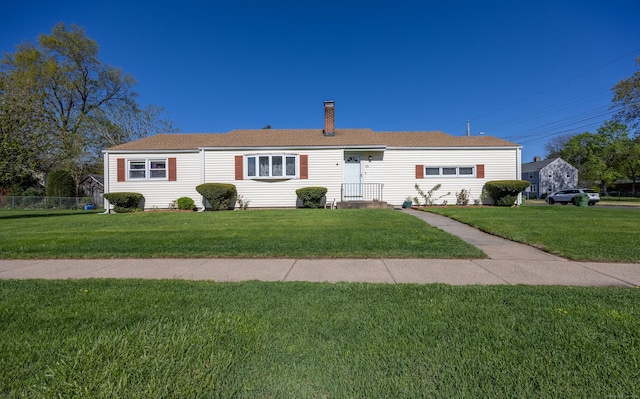 ranch-style home with a front lawn and a chimney