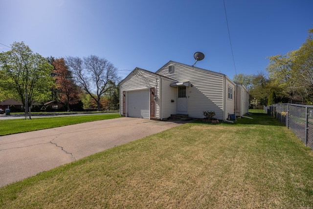 view of side of home with a yard, a garage, fence, concrete driveway, and entry steps