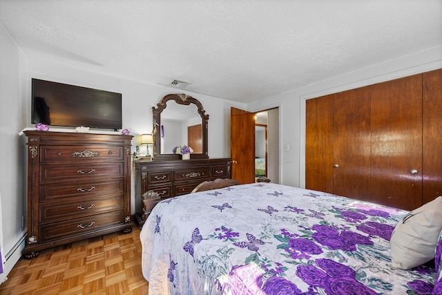 bedroom with a closet, visible vents, and a baseboard radiator