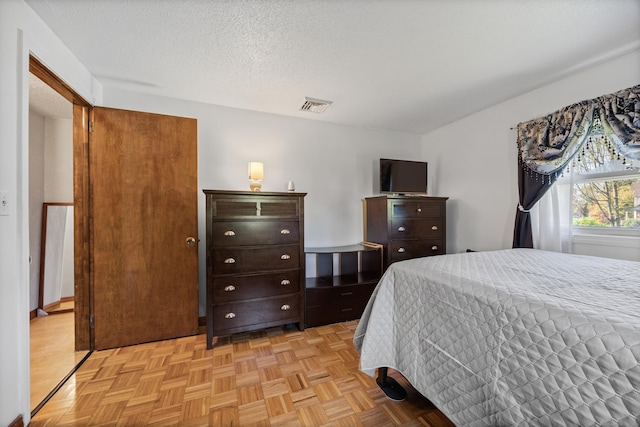 bedroom with visible vents and a textured ceiling