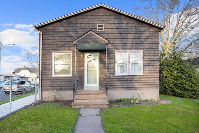 view of front of property featuring fence and a front lawn