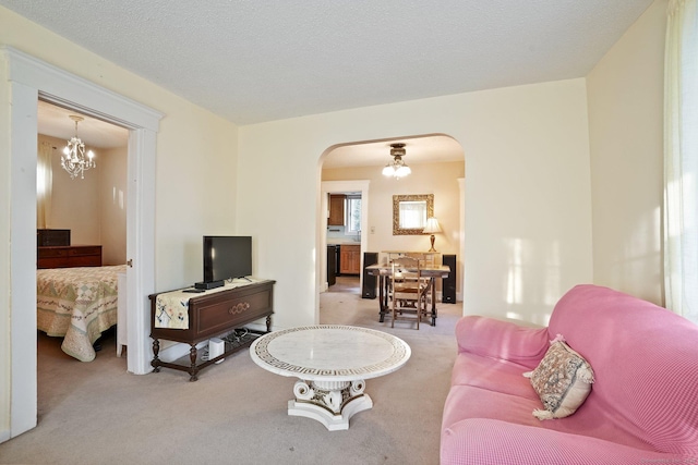living room featuring carpet floors, arched walkways, and a notable chandelier