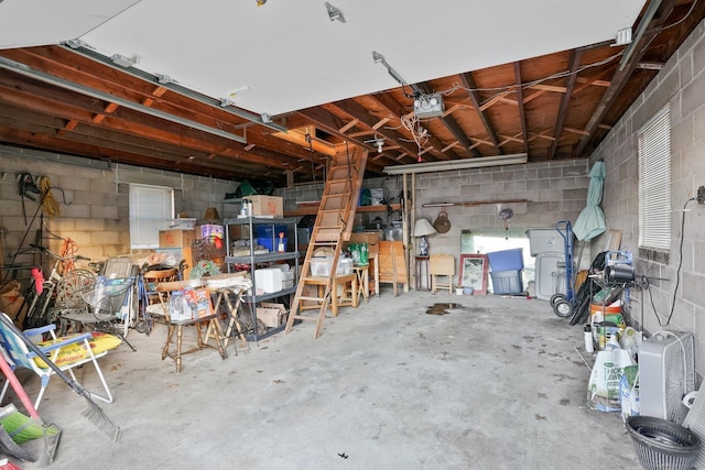 garage featuring concrete block wall and a garage door opener