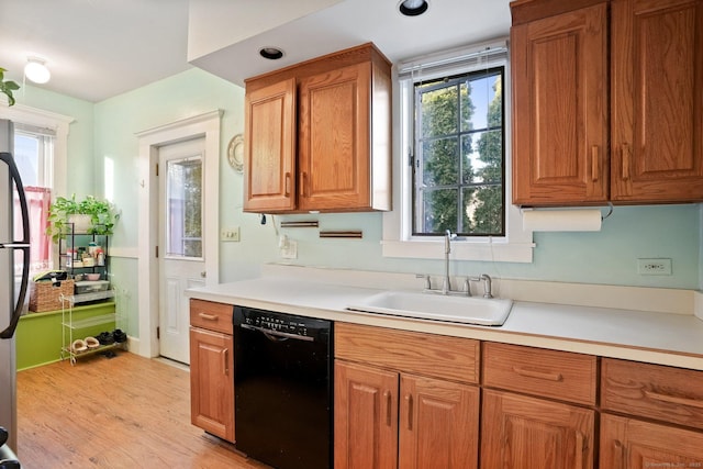 kitchen featuring a sink, light countertops, black dishwasher, and brown cabinets