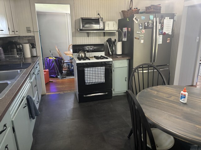45 Ivy St, Branford, CT 06405 - kitchen featuring gas range oven, freestanding refrigerator, dark countertops, tasteful backsplash, and a sink