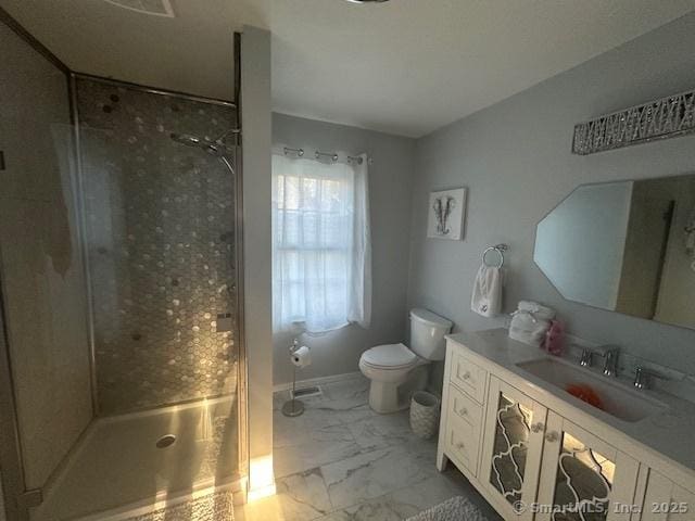 bathroom featuring vanity, marble finish floor, a stall shower, and toilet
