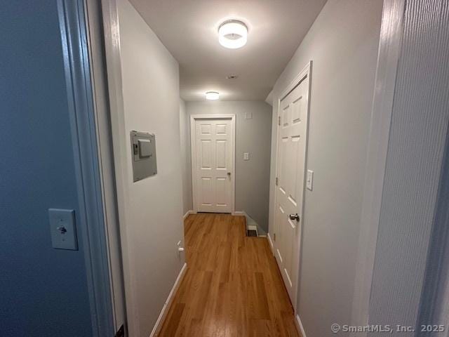 hallway with baseboards and wood finished floors