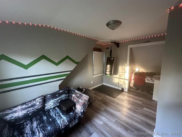 bedroom featuring baseboards, wood finished floors, and visible vents