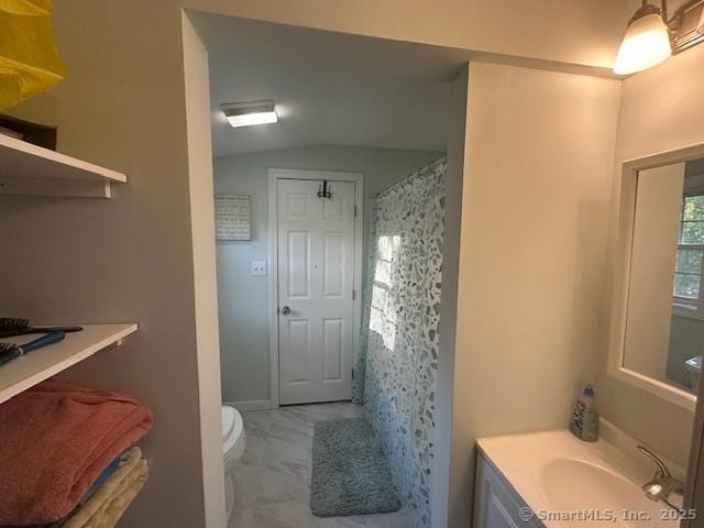 full bath featuring vanity, marble finish floor, curtained shower, toilet, and vaulted ceiling