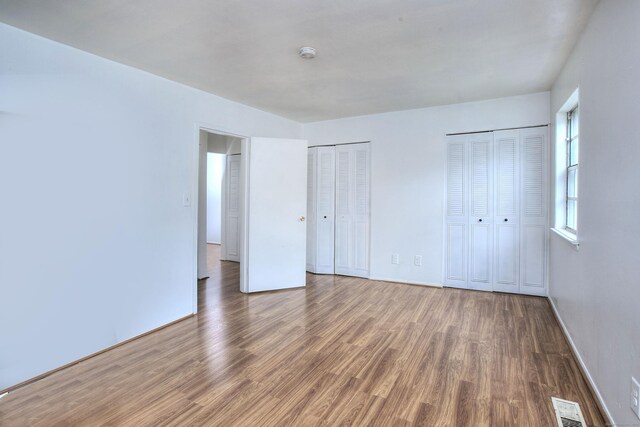 50 Greenhouse Rd Unit 17A, Bridgeport, CT 06606 - unfurnished bedroom featuring multiple closets, wood finished floors, and baseboards