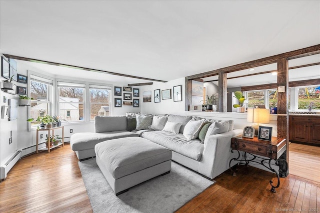 living area with baseboard heating and hardwood / wood-style floors