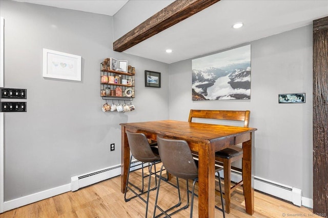 dining room with beamed ceiling, baseboards, a baseboard heating unit, and wood finished floors