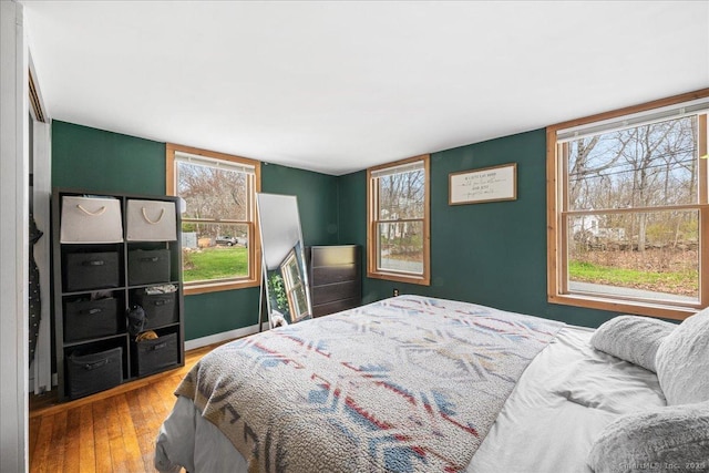 bedroom with wood-type flooring and baseboards