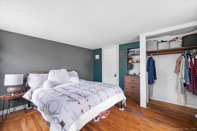 bedroom with baseboards, hardwood / wood-style flooring, and a closet
