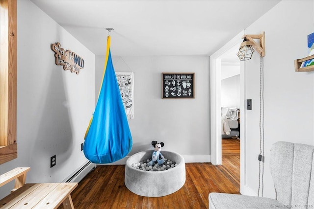 interior space featuring baseboard heating and wood finished floors