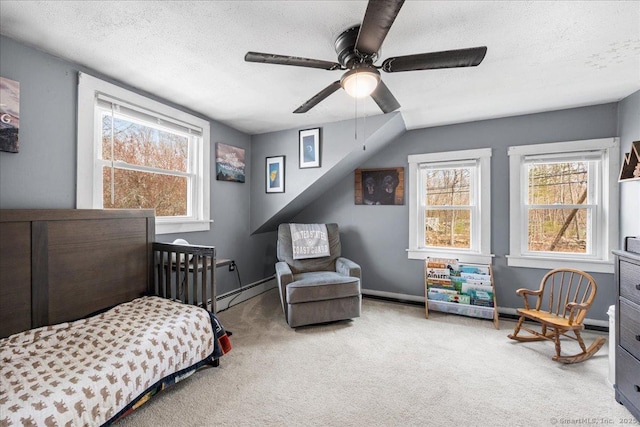 carpeted bedroom featuring a ceiling fan, a textured ceiling, a baseboard heating unit, and baseboards