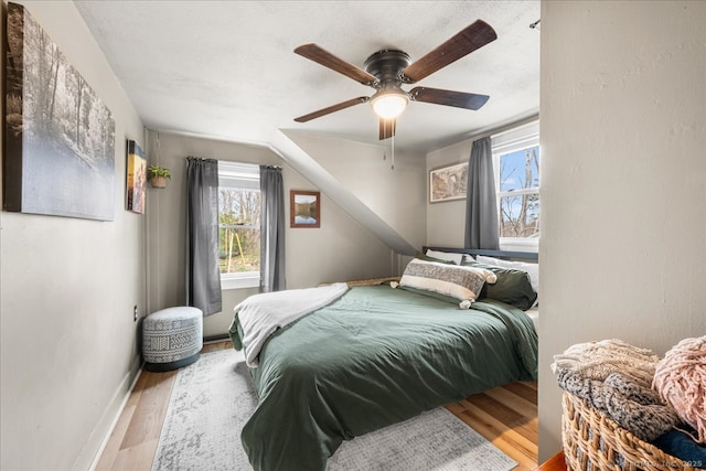 bedroom featuring baseboards, a ceiling fan, and wood finished floors