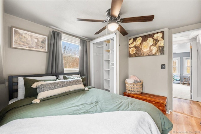 bedroom with ceiling fan, a closet, and wood finished floors